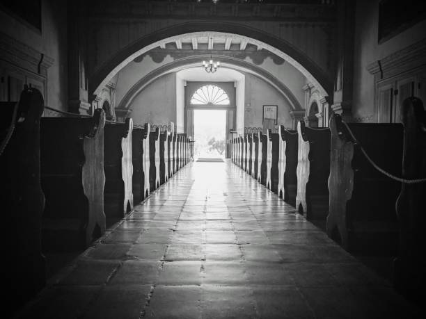 Windsor, UK - Apr 03, 2025 - Sunlight filtered through rows of Traditional church benches inside the church. View of The edge of the wooden pews, use it as your Wallpaper, Poster and Space for text, Selective focus.