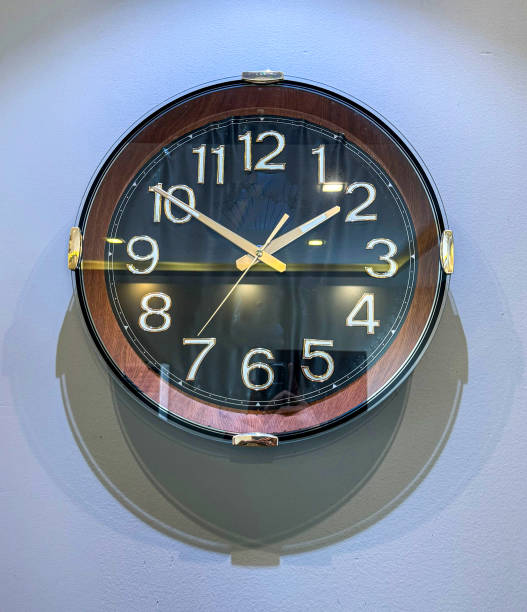 istock Analogue clock on white wall with shadow Time 1:50 1915436681