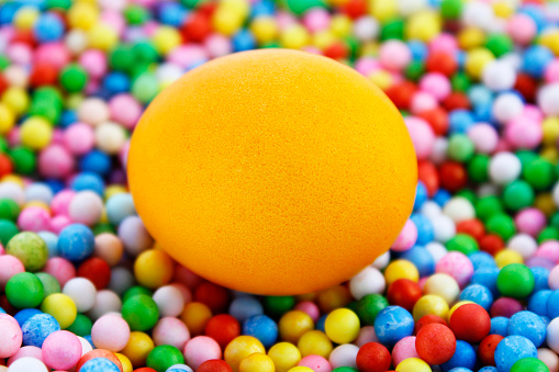 Orange egg on spheres of different colors