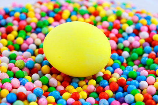 Yellow egg on spheres of different colors