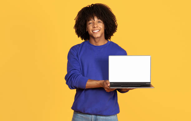 istock Check This Website. Smiling Black Guy Holding Laptop Computer With Blank Screen 1915481974