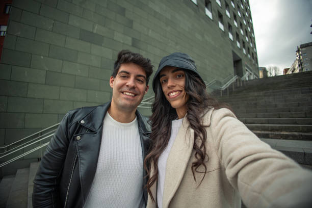 istock young couple taking selfie on stairs outside 1915525321