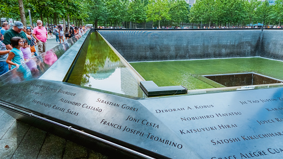People at Ground Zero Memorial Manhattan for September 11 Terrorist Attack with Engraved Names of Victims. Patriot Day - New York NY USA 2023-07-30.