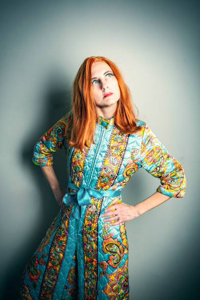 A woman with long red hair modeling a vintage 1960s paisley romper.