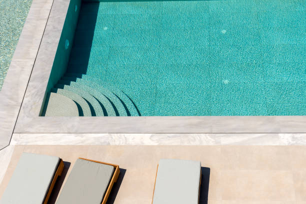 istock Top view of swimming pool with sunbeds. Summer backround. 1915604476