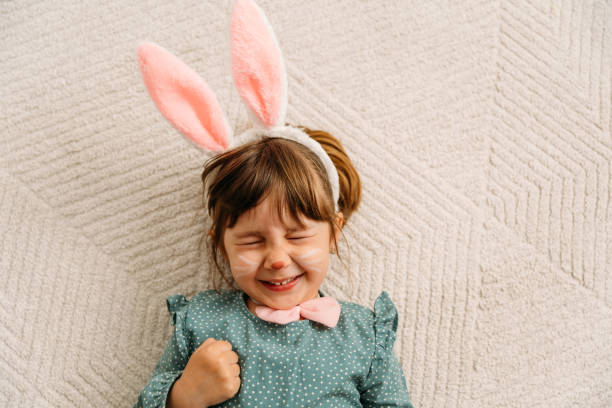веселая маленькая девочка с аквагримом в виде кролика easer - face paint фотографии стоковые фото и изображения
