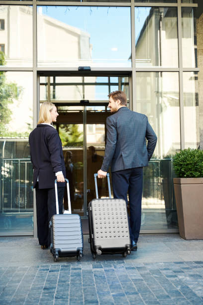 istock Smiling young couple with suitcases entering hotel 1915661240