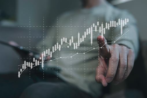 investment and finance concept, businessman holding virtual trading graph and blurred light on hand, stock market, profits and business growth.