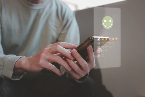 istock customer service evaluation and feedback rating. costumer review concept, man using phone chooses happy smiling face 1915715085