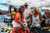 African American senior couple with local tour guide at Hawaii farmers market