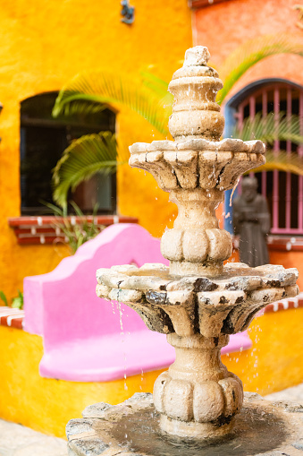 In Playa del Carmen, Mexico a fountain marks the entrance of a colorful Hacienda style hotel.