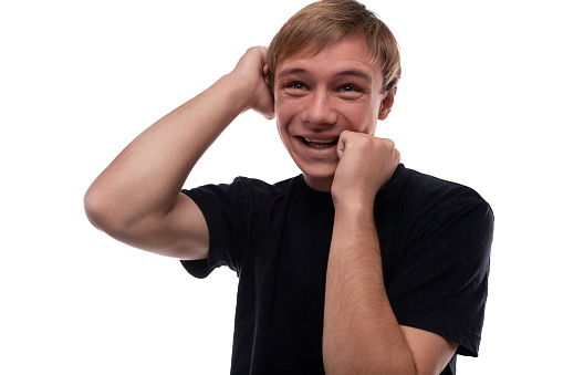 Smart teenager guy in a black T-shirt thinking against a background with copy space.