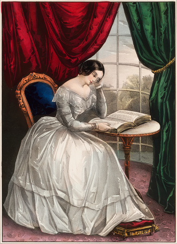 Vintage image features a young woman in a white dress reading the Bible.