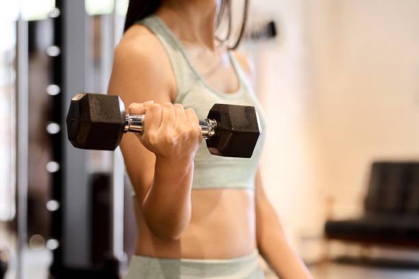istock Woman training her arms with dumbbell arm curls 1915876510