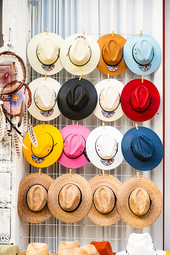 In Playa del Carmen, Mexico an assortment of hats are displayed for sale on an outdoor sales rack.