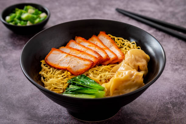 istock Egg noodle with red roasted pork and wonton in black bowl 1915917764