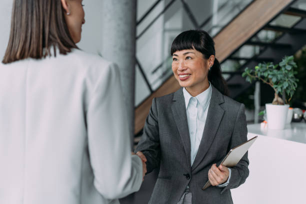 istock Business persons shaking hands in office. 1915928699
