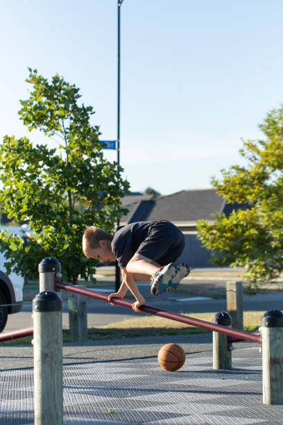 An active boy performs a parkour exercise on a sports field. A boy is training outside.