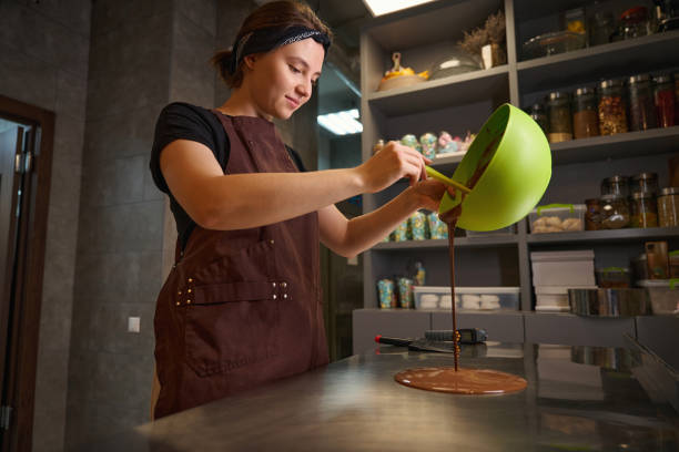 Young female confectioner busy with candy making