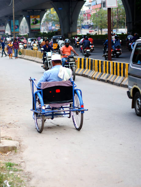 HYDERABAD<INDIA-MARCH 2, 2021: View of physically handicapped or physically disabled man use hand operated tricyle on a busy road