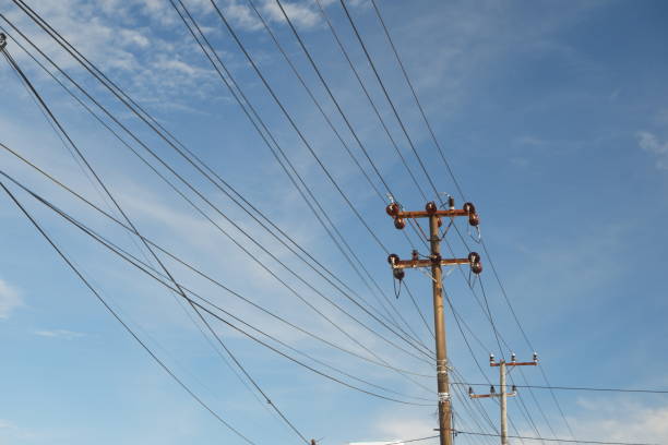 istock Electric cable poles against a bright blue sky 1916087838