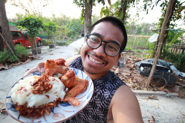 south asian man eating fried chicken