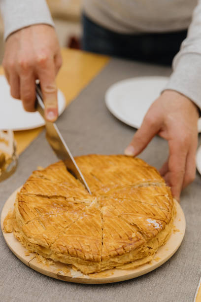 istock A young man cuts a royal galette at the table. 1916107090