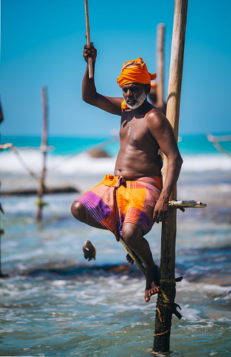 Koggala, Sri Lanka -December 13, 2023:
Stilt fishermen fish in the traditional way in shallow water in Koggala, Sri Lanka.