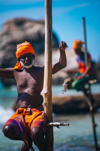 Koggala, Sri Lanka -December 13, 2023:
Stilt fishermen fish in the traditional way in shallow water in Koggala, Sri Lanka.