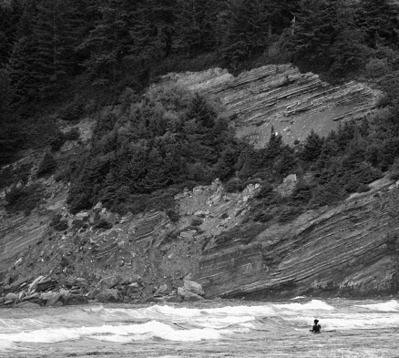 A lone surfer waits for her set in the Autumn surf.