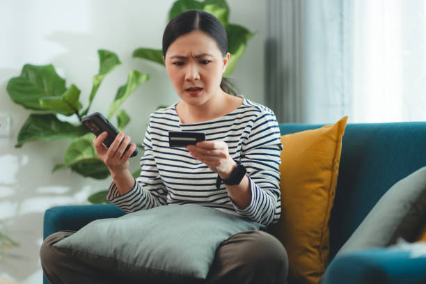 istock Asian woman holding credit card using smartphone have a problem with shopping and paying online. 1916167732