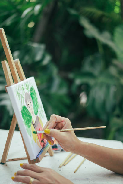 istock Hand uses a paintbrush to paint on a frame. 1916215637