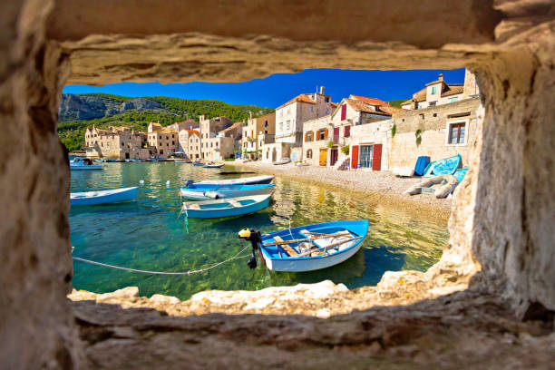 istock Scenic beach in Komiza waterfront view through stone window 1916230614