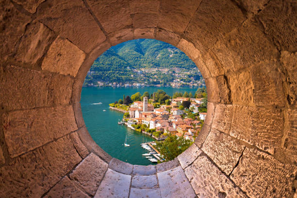 Idyllic town of Torno on Como lake view through stone window, Lombardy region of Italy