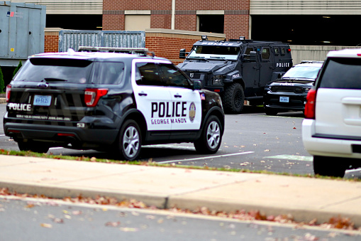 Fairfax, Virginia, USA - November 11, 2023: George Mason University police cruisers and a tactical vehicle parked on the GMU’s main campus.