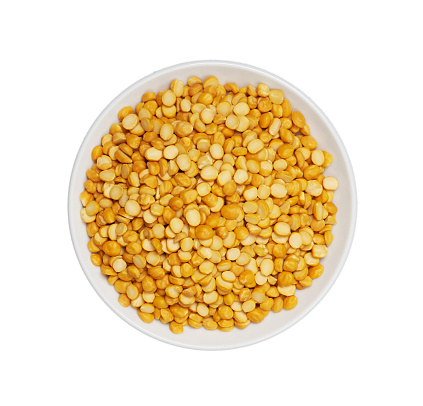 top view flat lay pile of split bengal gram or chana dal isolated on white background. heap of split bengal gram or chana dal isolated. split bengal gram food in white bowl