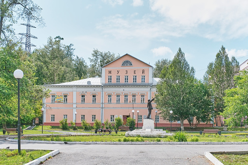 Zlatoust, Russia - June 20, 2023: City local history museum. Formerly the House of Mining Authorities. Historic building from late 18th century in city center. Historical monument to Lenin. Cityscape