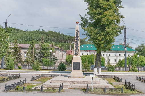 Zlatoust, Russia - June 20, 2023: Monument-obelisk at mass grave of 27 participants of Bolshevik underground, shot in 1918-19. Cityscape on summer day. Travel concept