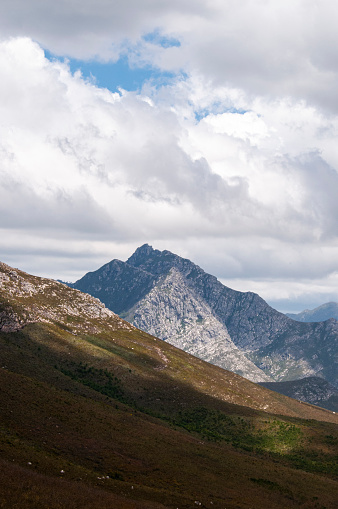 dramatic mountain view with sky, clouds and rugged peaks in a mountainous landscape in the fynbos cape mountains of South Africa