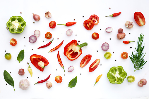 Various fresh vegetables and herbs on white background.