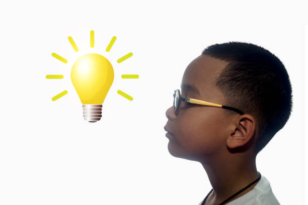 Boy looking up and thinking with light bulb. Creative idea. Concept of idea and innovation