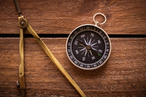 Vintage drawing and navigational Compass on a rustic wooden board