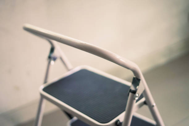 Foldable wooden chair transforming into stepladder on white background