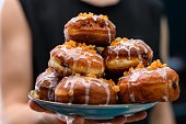 Homemade donuts with icing and orange peel stack on a plate