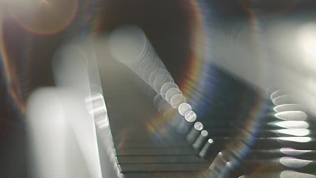 Female hands playing on a synthesizer keyboard (piano) shining in the backlight