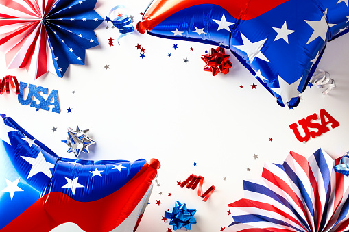 USA Independence Day party decorations on white background.. Red blue and white balloons, paper fans, stars. Presidents Day, American Labor day, Memorial Day, US election concept.