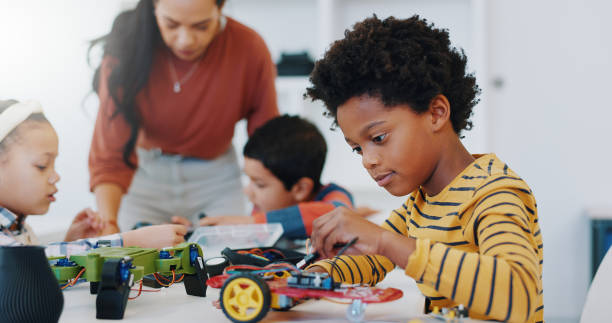 istock Technology, boy and car robotics at school for learning, education or electronics with car toys for innovation. Classroom, learners and transportation knowledge in science class for research or study 1916552618