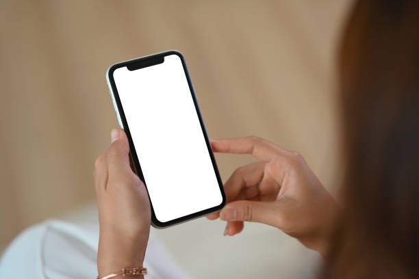 istock Closeup young woman holding mobile phone with white empty screen for application advertising 1916571753