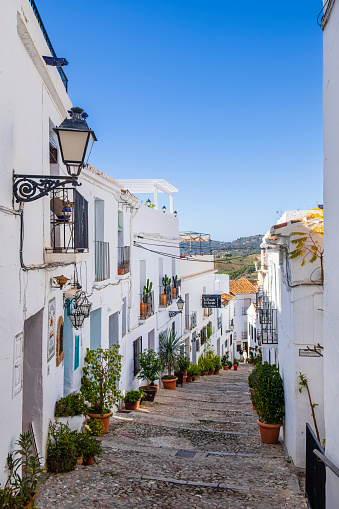 Narrow alley lined with traditional whitewashed houses in the historic centre of Frigiliana, one of the most beautiful towns in the Costa del Sol