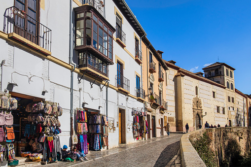 Tourists strolling in the Carrera del Darro, a narrow cobblestone street, one of the oldest and charming in the city, where, among the historic buildings, stands out the Convent of Dominican nuns dedicated to St. Catherine of Siena, founded in 1520.